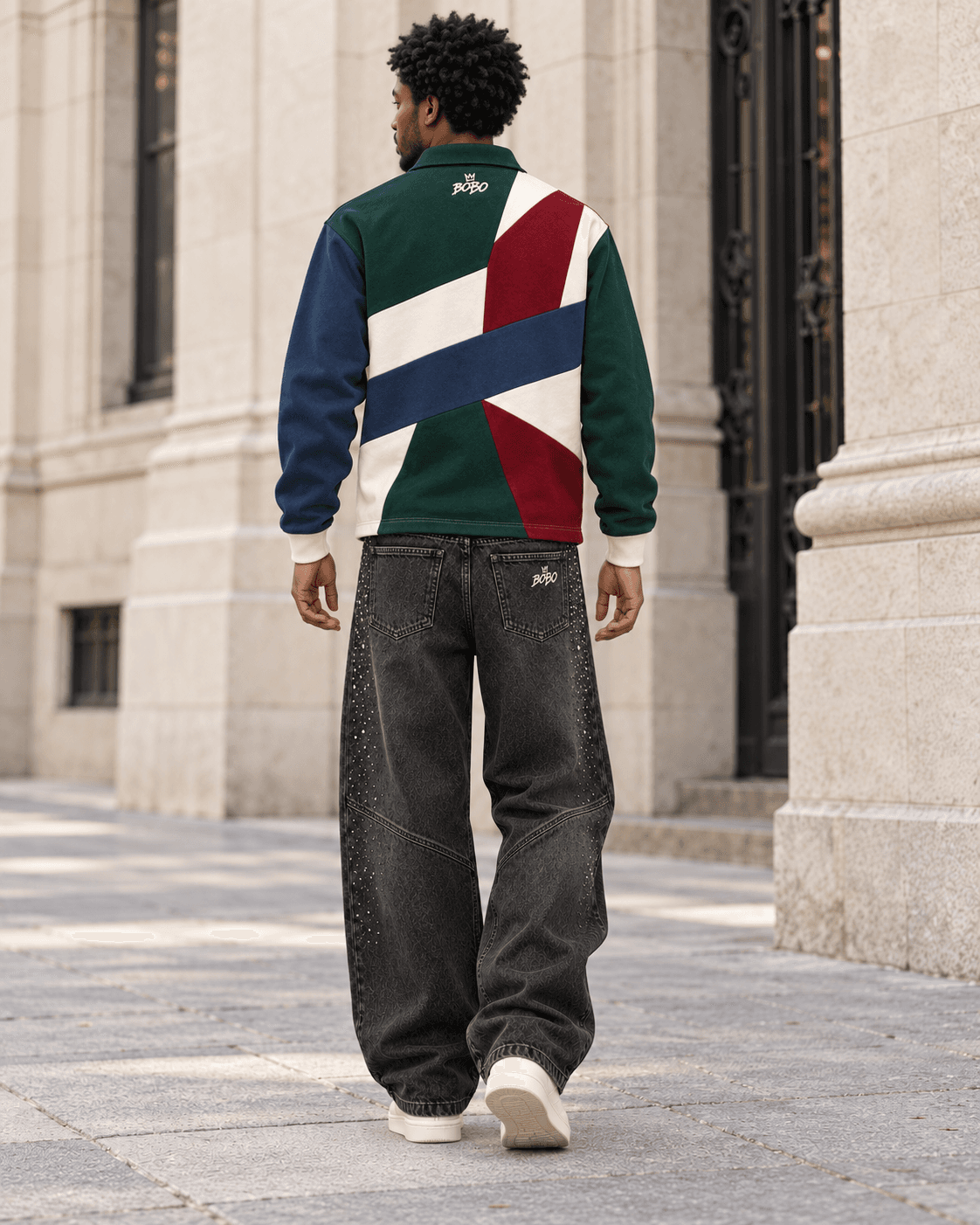 Rear full-body view of the BOBO patchwork rugby polo and crystal charcoal wide-leg denim while walking along a pale stone street